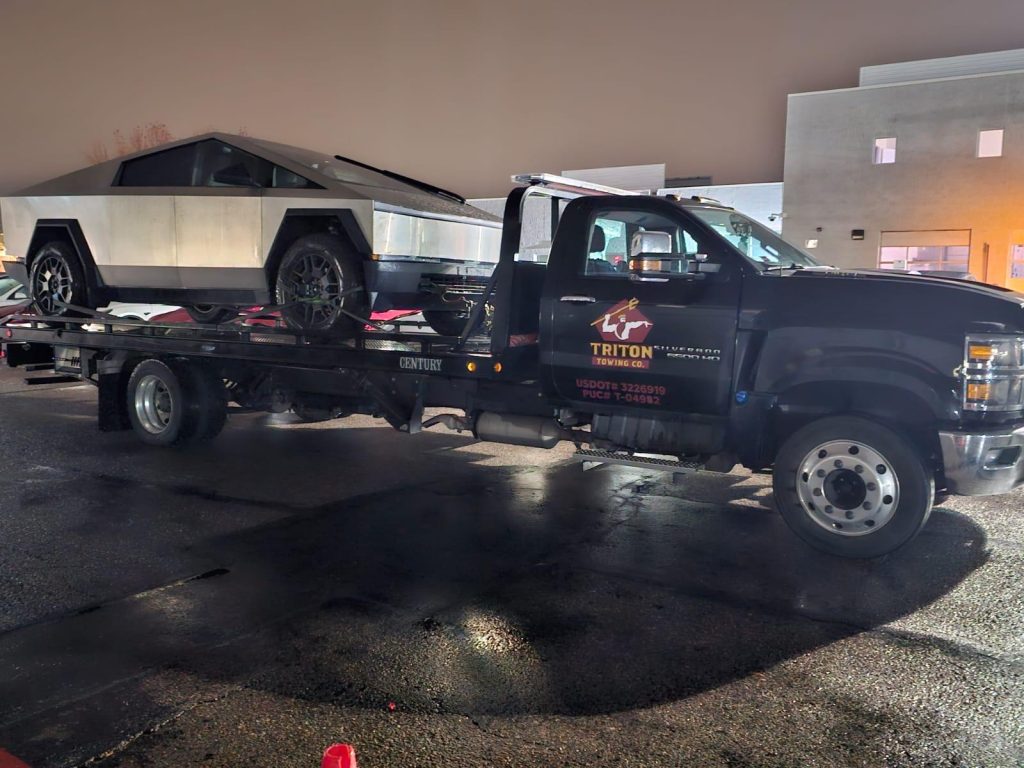 Skilled tow operator securing vehicle carefully with professional towing equipment